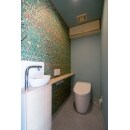 コンパクトにまとまったトイレ。しかし収納棚には木の縁取りを、アクセントウォールの壁紙はモダンデザインのモリス風をあしらいました。