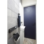 ブルーのドアとエコカラットの石積みの雰囲気が上質空間のトイレ