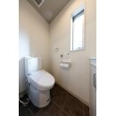 窓のある明るいトイレには、省エネ効果のある節水トイレを採用。右側の収納スペースはカウンター収納にして、圧迫感をなくしました。