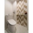 1階トイレは交換して間もない既存のトイレをそのまま使用。壁のアクセントにタイルを使いアーティスティックなモダンデザインに。