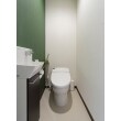 タンクレストイレで空間を広く、手洗いキャビネットも設置。
落ち着いたグリーンのアクセントクロスが印象的なトイレ