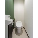 タンクレストイレで空間を広く、手洗いキャビネットも設置。
落ち着いたグリーンのアクセントクロスが印象的なトイレ