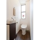 節水タンクレストイレに変更し、手洗いキャビネットを設置。
白い壁とダークな木目の床がシンプルでシックに。