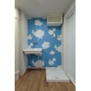 洗面所スペースは、青空で明るく楽しくなるような壁紙を採用。