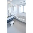 清潔感のある白の浴槽。窓からの光は洗面所を通過し、廊下まで差し込みます。