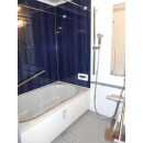 深いブルーのアクセントパネルが素敵なバスルーム。バスタブ横には手摺を取付しています。浴室換気暖房機でお洗濯物を乾かすため、ランドリーパイプを２本取り付けました。