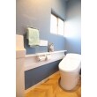 タンクレス風のすっきりとしたデザインのトイレ。
床は、ヘリンボーン柄の塩ビタイル。
カラークロスと組み合わせて、ヨーロッパのような雰囲気に。