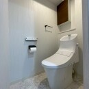 トイレも洗面所同様白を基調とした中に、木目調の扉の収納とブラックのアクセサリーがポイントのモダンで落ち着いたインテリアにしました。トイレ本体はリクシルの「アメ―ジュZA」を採用しました。