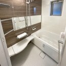 浴室はお掃除もラクラクなリノビオ。すっきりとしたデザインの中に横長のミラーとコーナーの使いやすい棚が便利です。ブラウンの木目調のパネルをお選びいただき、高級感があるゆったりとくつろげる浴室になりました。