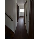 廊下は幅も長さもそのままです。
暗くなる事を防ぐためにクロスは白でシンプルに施工しました。
ドアと廊下の木目は、重厚感のある濃い色でシンプルさを引き立てています。