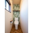 トイレは背面にアクセントクロスを採用しました。小さな空間ですが、正面のドアを開けるとパッと目に入るグリーンがとても鮮やかです。色の効果でクリーンな印象にもなりますね。