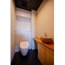 トイレは宙に浮いたように見えるフロートトイレ。
手洗いカウンターは杉の無垢板に明山さんの火力丸型手洗い鉢を採用。