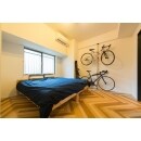 寝室は、明るい床色のヘリンボーン仕上げに。自転車を飾れるようポールを設置。