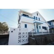 アメリカンハウスにするために外壁や屋根を白と水色で塗装しました。また、沖縄県でよく利用される花ブロックが特徴的な門扉も建物と合わせた白で塗装しました。