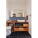 ブルーのタイルと黒の床材の組み合わせがかっこいい洗面。