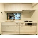 優しいホワイトと木の質感を取り入れたキッチンパネルとセラミックのワークトップで仕上げたキッチン。