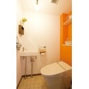 オレンジ色の壁が印象的なスタイリッシュトイレです。