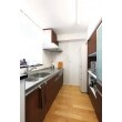 キッチンの扉材と、背面の収納の扉材を同素材で統一。さらに、キッチンカウンターも同色でつくり、統一感を出しています。