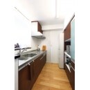 キッチンの扉材と、背面の収納の扉材を同素材で統一。さらに、キッチンカウンターも同色でつくり、統一感を出しています。