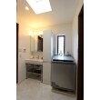 洗面所には、すっきりとしたシンクと壁面収納を設置。三面鏡上部には、間接照明を設置。