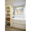 キッチンのパントリーと同じアールのデザインを取り入れた収納スペースが洗面空間のポイントに。