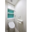 収納背面にターコイズ調の鮮やかなブルーのアクセントクロスを貼ったトイレ