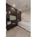 磁器タイルのフロアにブラウンのアクセントパネルが高級感のある浴室。