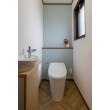 2階のトイレはリクシル「サティスS」へリフォーム。内装もヘリンボーンのクッションフロアと、ブルーグレーのアクセントクロスで1階のトイレとはイメージを変え、北欧テイストのナチュラルな空間に仕上がりました。
