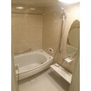 温かな雰囲気でくつろげそうなバスルームです。丸みのある形のミラーや浴槽がおしゃれです。