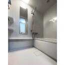 ホワイトの鏡面仕上げの壁パネルで明るく清潔感が増した浴室へ。