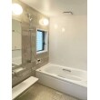 ホワイトをベースにアクセントパネルと床にベージュの優しい色合いの明るい浴室に。
