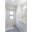 洗面所は白で統一された壁・天井に、ターコイズブルーの爽やかなアクセントを加えたインテリアに仕上がりました。洗濯パンも新しく設置して、照明もダウンライトに変更しています。