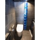 トイレもLDK、浴室と雰囲気を合わせ、ダークグレーのタイル張りに。アクセントにブルーのガラスブロックを壁に設置し、照明を当てました。
