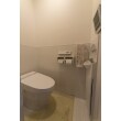 大好評のLIXILのサティス、タンクレスで自動で流れるトイレです。
床はホーロー貼りで寒さ対策を施していますし、紙巻器は磁石で付く便利ものです。