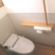 棚手摺と腰壁にメラミン化粧板（鏡面仕上げでお掃除楽々）を採用しました。奥行きの少ないトイレでもタンクレストイレなら広さも確保できます。