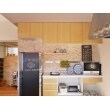 キッチンスペースには収納スペースを広くとっており、造作で小物棚も取り付けてある。レンガ調の壁もかわいい。
