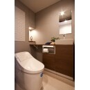 トイレは、LIXIL（プレアス・アイボリー色）を採用しています。奥の角スペースを利用して、ライトアップできるニッチと収納を造り込みました。また、消臭・調湿効果のあるエコカラットは絵画の様に壁面を飾ってくれています。