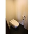 黒と白のコントラストが効いているトイレ。
座った時に目に入る面にグレーのエコカラットを貼ることで、色と素材で高級感をプラスしています。
