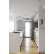 キッチンはペニンシュラ型で配置されており、鏡面仕上げの面材は高級感と清潔感を感じさせます。