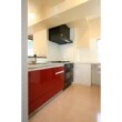 赤と白に統一されたキッチンスペースには、周囲に造作収納を設置。使い勝手の良い広々とした無駄のないキッチンスペースを実現させた。