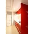 空間にスパイスを効かせている赤のキッチン。台所に立つたびに明るい気持ちになります。リビングと寝室にもスペースを確保させるため、幅は180ｃｍとコンパクトサイズをチョイス。ミリ単位で可能な限りキッチンスペースを確保出来るように設計されています。