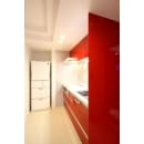 空間にスパイスを効かせている赤のキッチン。台所に立つたびに明るい気持ちになります。リビングと寝室にもスペースを確保させるため、幅は180ｃｍとコンパクトサイズをチョイス。ミリ単位で可能な限りキッチンスペースを確保出来るように設計されています。