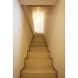 １階から２階へ上がる階段です。正面にライトを配し、壁をライトで照射させています。上階に上がるための通路としてしか考えられない階段も、ちょっとした工夫でオシャレ感を表現することができます。