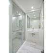 洗面室、浴室、トイレなどの水回りは、ホワイトの天然石とガラスドアで仕切られた透明感のある空間にまとめられています。明るく煌びやで、ホテルのスイートルームのようなラグジュアリースペースです。