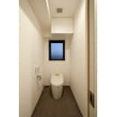 もともとついていたトイレは位置を変えずにタンクレスのネオレストに交換し、すっきりとした印象のトイレに仕上げています。天井には2方向に出ている梁をうまくかわしながら吊戸棚を設置しています。