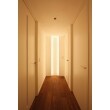 廊下の突き当たりにも、玄関正面と同じデザインのタイル・照明を施工しました。ほの暗い廊下に間接照明を取り入れると、安心感のある印象になります。