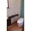 1階のトイレは、タンクレスの便器に手洗い器の組み合わせ。壁紙も正面の壁はアクセントに。