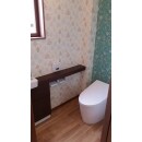 1階のトイレは、タンクレスの便器に手洗い器の組み合わせ。壁紙も正面の壁はアクセントに。