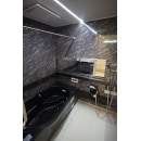 ブラックの浴槽と大理石調壁パネル
天井のフラットラインLED照明が高級感のある浴室を演出。