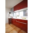リビングの内装を白に統一したことで、キッチンの赤が空間のアクセントとしてぐっと映えています。